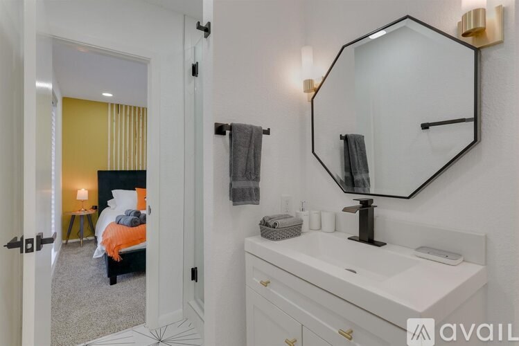 A bathroom with a white vanity and a mirror above it.