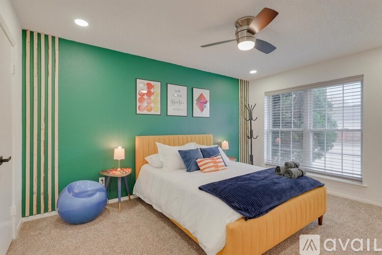 A bedroom with a bed, a ceiling fan, and a window with blinds.