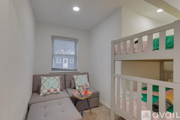A small room with a grey couch and a bunk bed.