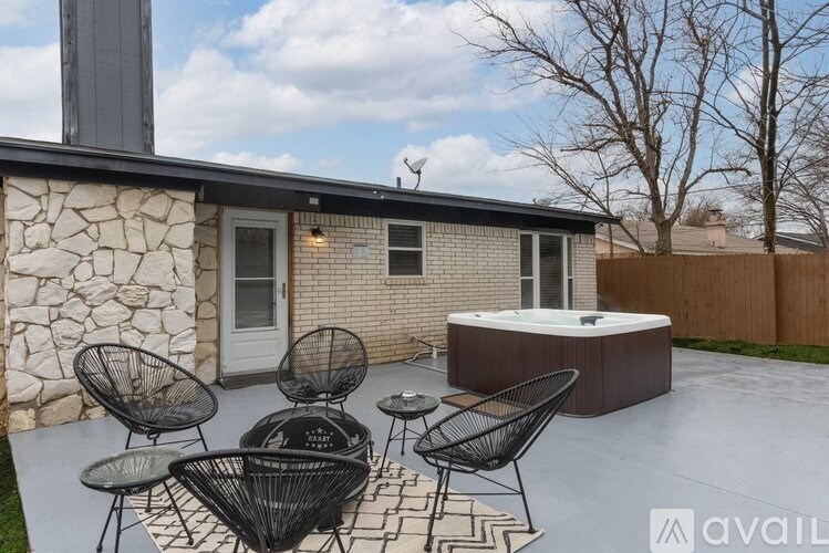 A patio with a hot tub and chairs is available for rent.