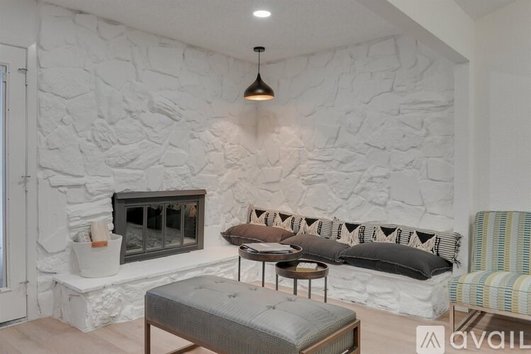 A living room with a stone wall and a grey sofa.