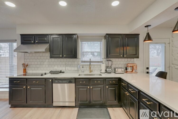 A kitchen with dark cabinets and a white countertop.