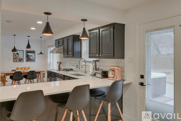 A kitchen with black cabinets and a white countertop.