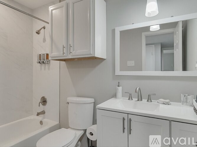 A white bathroom with a toilet, sink, and bathtub.