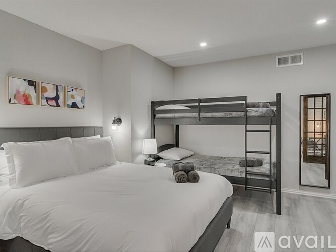 A bedroom with a white bed and a bunk bed.