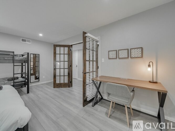 A bedroom with a bunk bed and a desk with a chair.