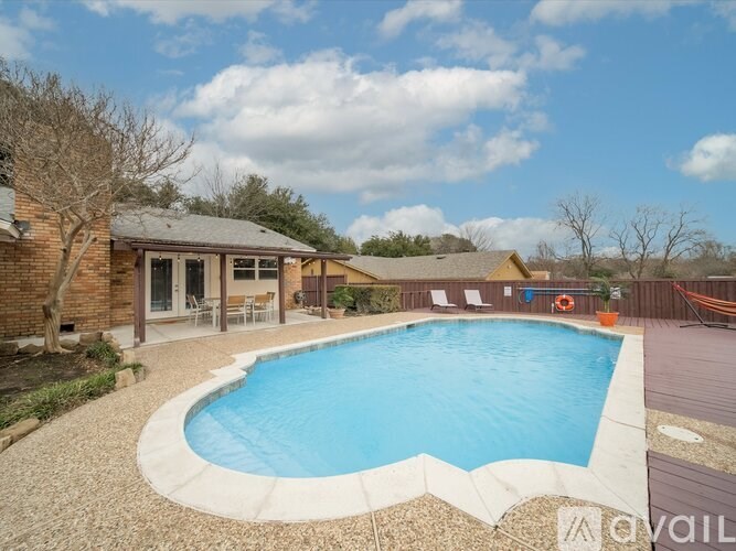 A backyard with a pool and patio furniture.