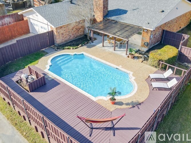 A backyard with a pool and deck.