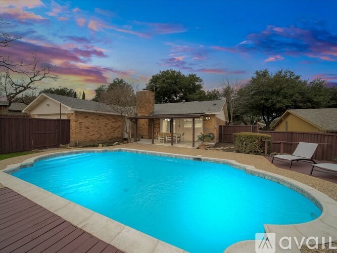 A backyard with a pool and a house.