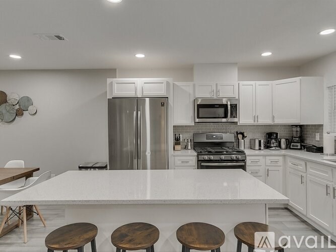 A modern kitchen with a large island and stainless steel appliances.