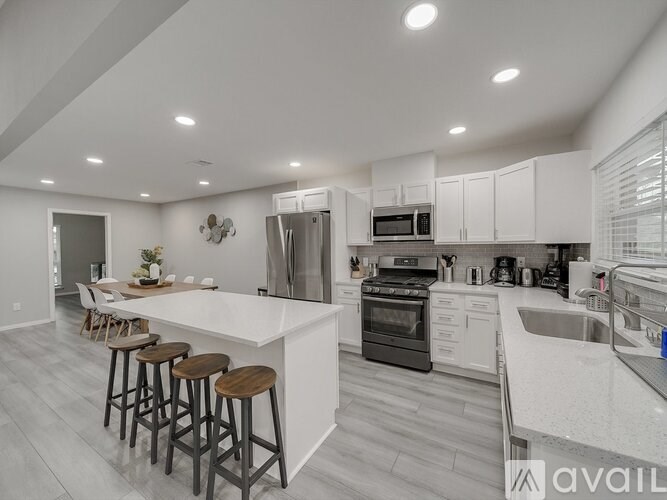 A modern kitchen with white cabinets and a large island.