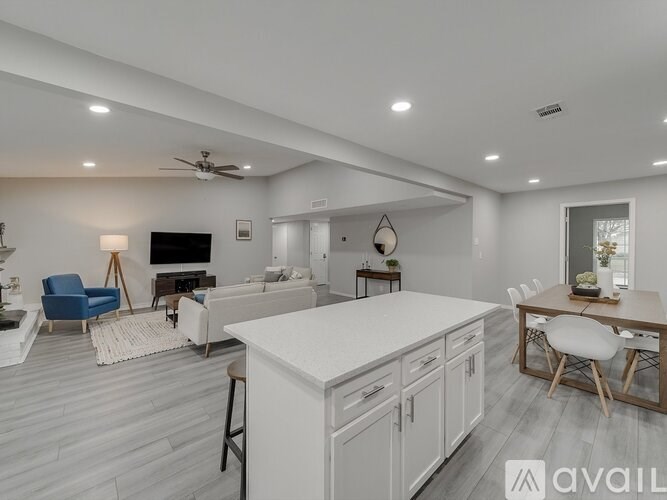 A modern kitchen with white cabinets and a dining table with chairs.