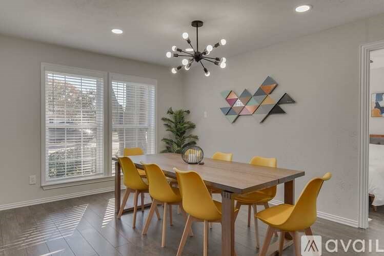 A dining room with a wooden table and yellow chairs.