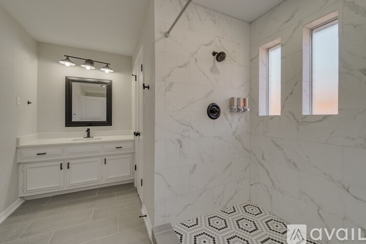 A bathroom with marble walls and a white vanity.