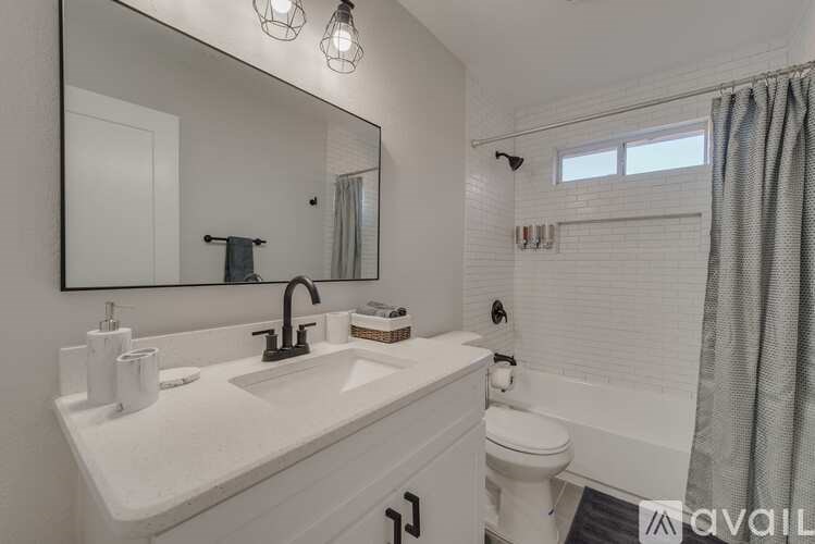 A bathroom with a white sink and toilet.