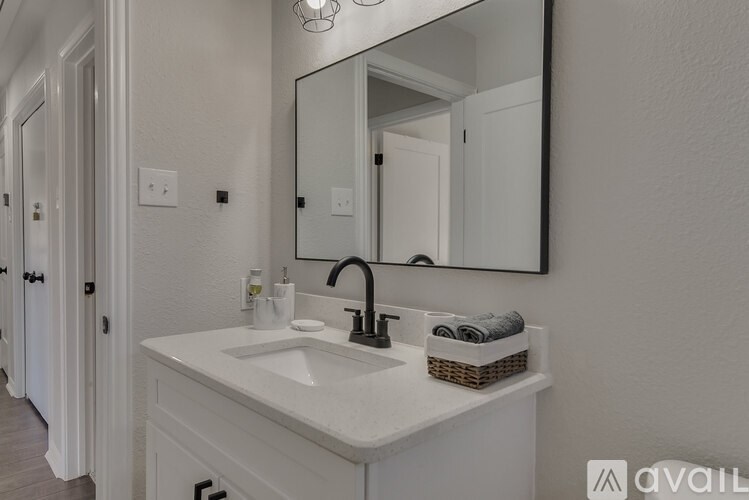 A bathroom with a white sink and a mirror above it.