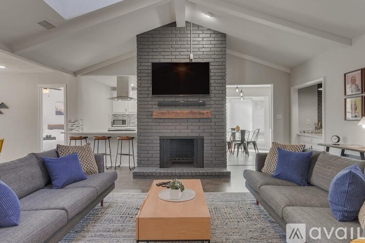 A living room with a grey couch, a coffee table, and a fireplace.