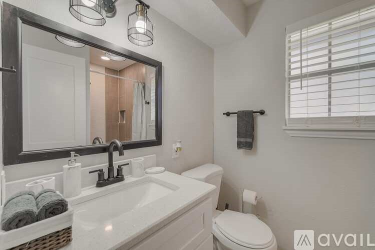 A bathroom with a white sink and toilet.