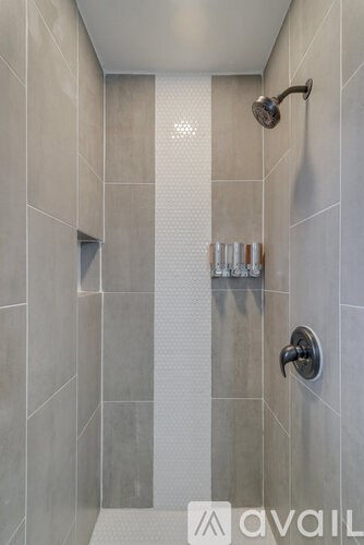 A shower area with a glass door and a shower head.