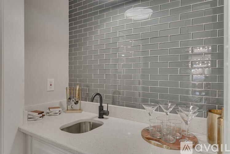 A kitchen with a sink and a tiled backsplash.