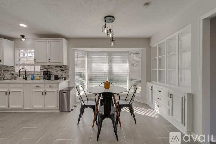 A kitchen with a dining table and chairs.