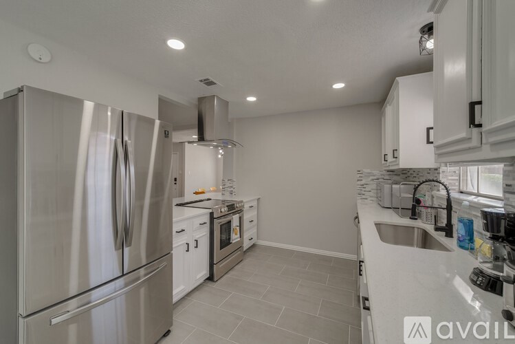 A modern kitchen with stainless steel appliances and white cabinetry.