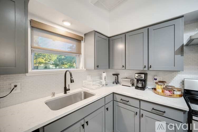 A kitchen with a sink, a window, and a toaster.