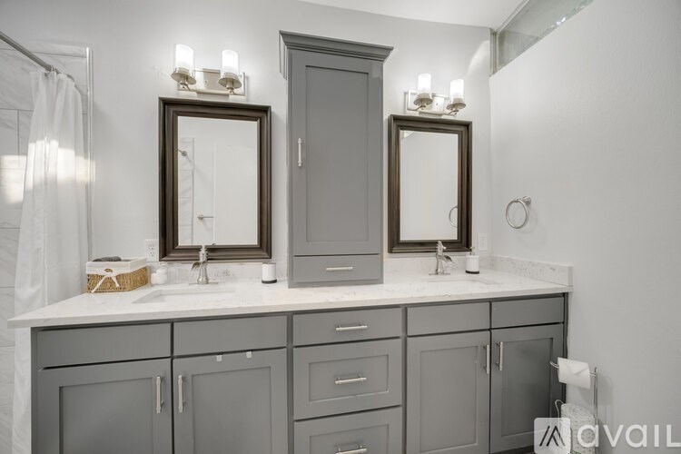 A bathroom with a vanity and two mirrors.