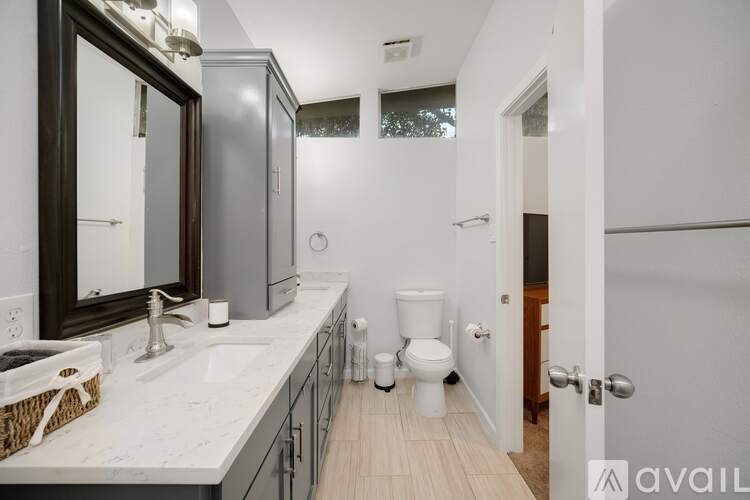 A bathroom with a white counter top and a white toilet.