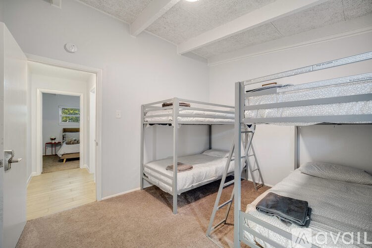 A room with two bunk beds and a ladder.