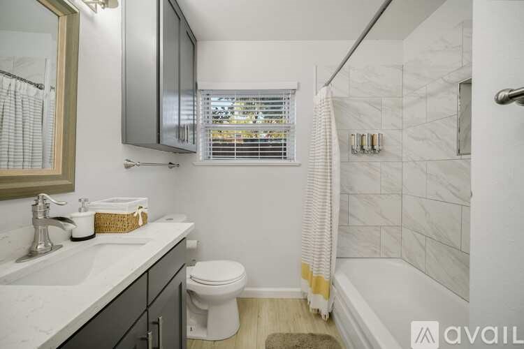 A bathroom with a toilet, sink, and a shower.