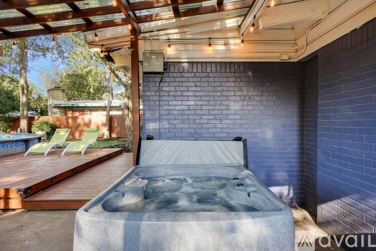 A bed with a hot tub in the middle of it is in the foreground of the image.