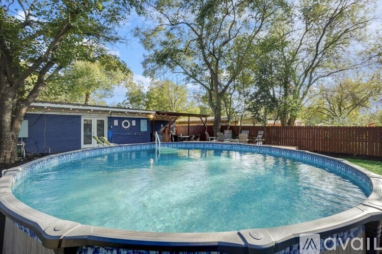 A small pool with a blue border and a white fence.