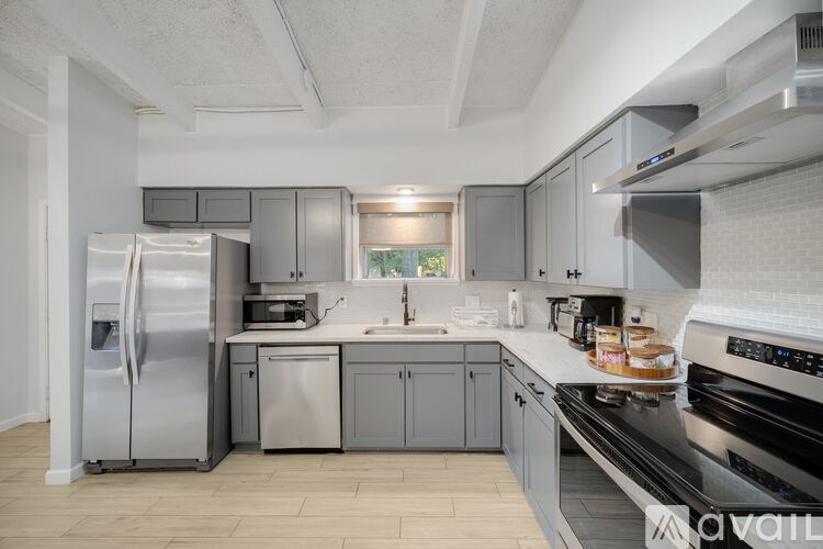 A kitchen with a stainless steel refrigerator and a stove top oven.