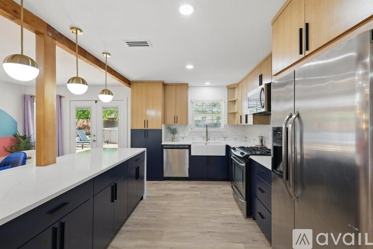 A modern kitchen with wooden cabinets and stainless steel appliances.
