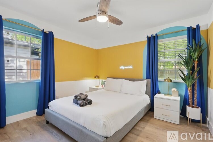 A bedroom with a bed, nightstand, and a ceiling fan.