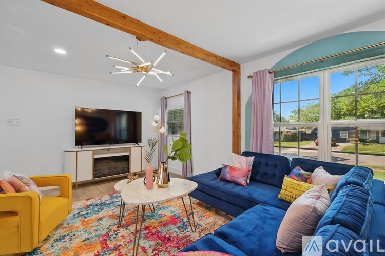 A living room with a blue couch and a white coffee table.