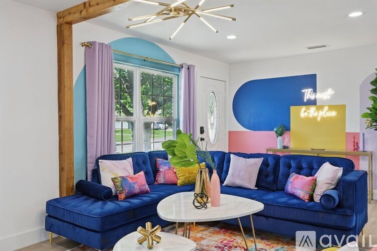 A living room with a blue couch and a white coffee table.
