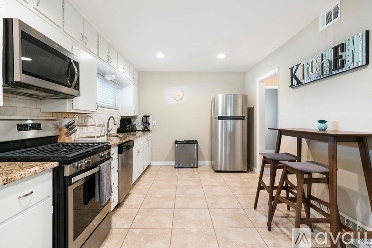 A kitchen with a black stove top oven and a white microwave above it.