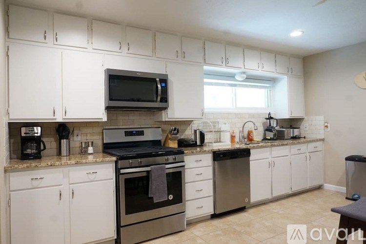 A kitchen with white cabinets and a black stove top oven.