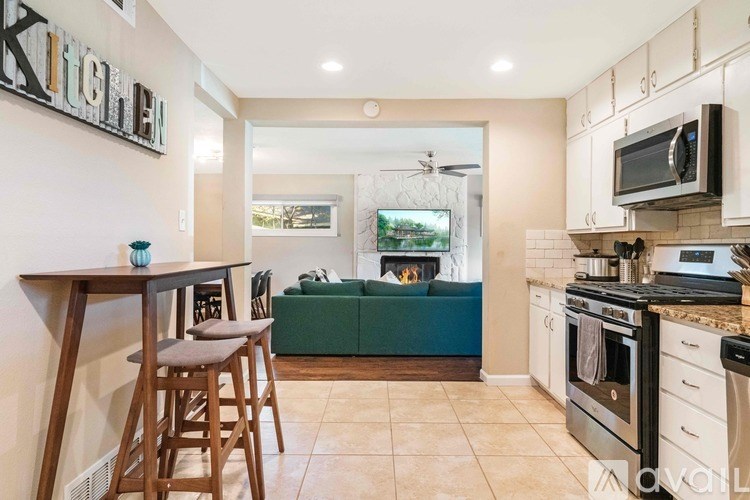 A kitchen with a bar stool and a counter.