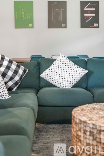 A living room with a green couch and two pillows.