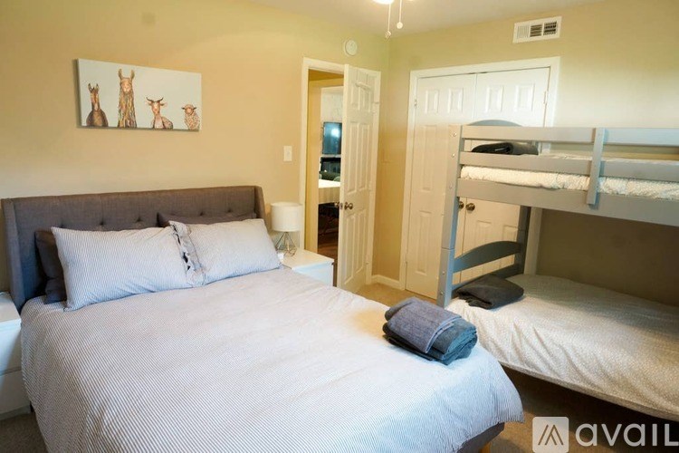 A bedroom with a bed, a bunk bed, and a painting of two deer.