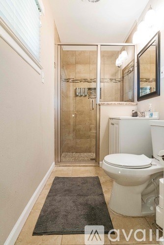 A bathroom with a toilet, sink, and shower.