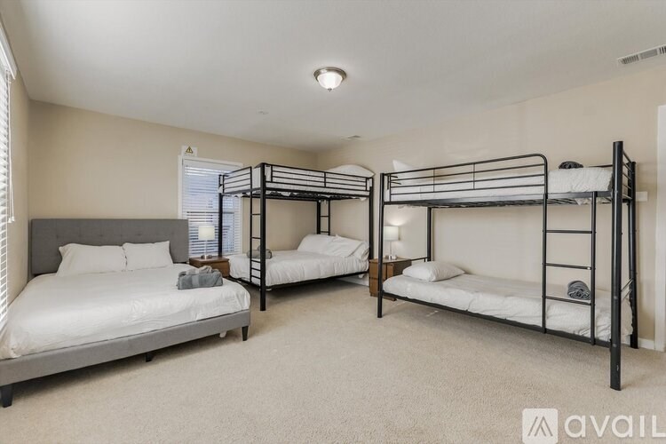 A bedroom with two bunk beds and a single bed.