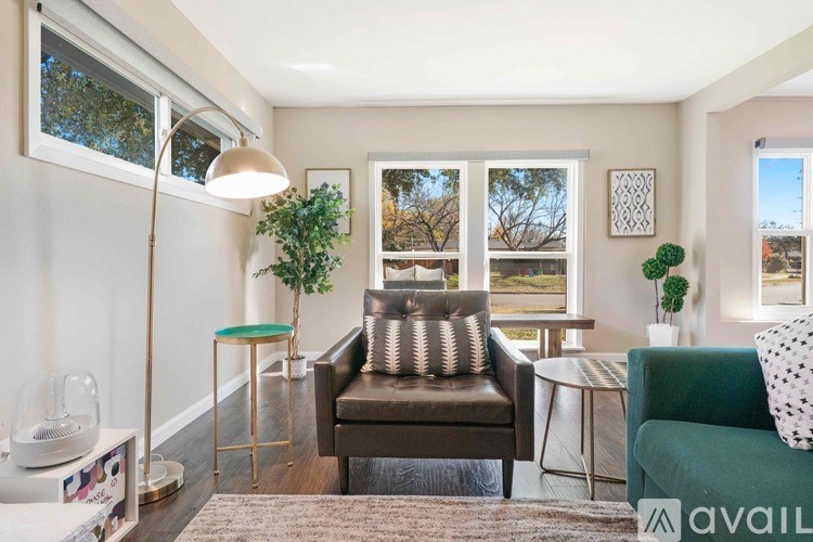 A living room with a brown leather chair and a green armchair.