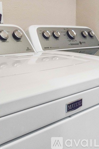 A white Maytag washing machine with the door open.