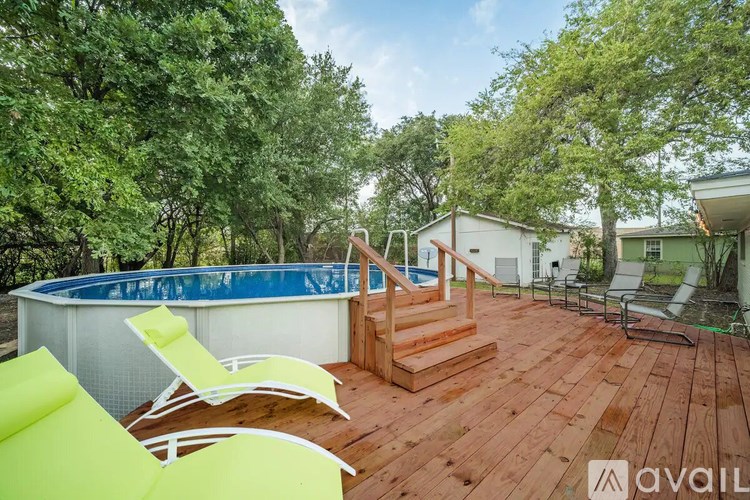 A wooden deck with a pool and chairs.