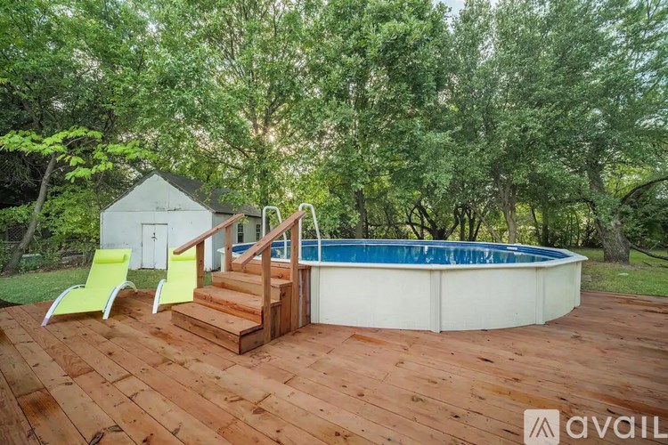 A wooden deck with a pool and stairs leading to a house.
