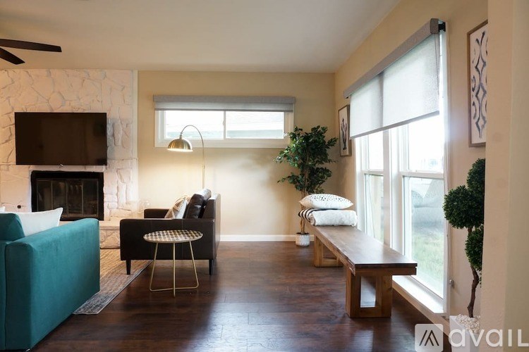 A living room with a green couch, a fireplace, and a television mounted above it.